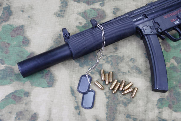 istock submachine gun MP5 with silencer on camouflaged background 1206087714