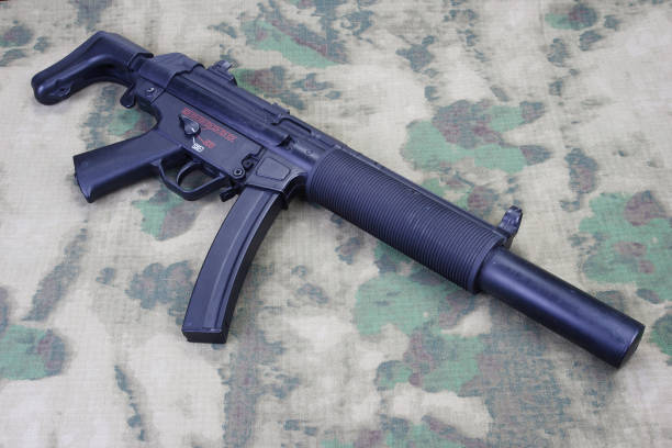 istock submachine gun MP5 with silencer on camouflaged background 1206087715