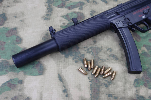 istock submachine gun MP5 with silencer on camouflaged background 1206087720
