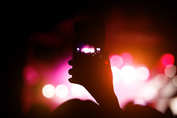 istock Man using smartphone to take a video at a concert 1206089761