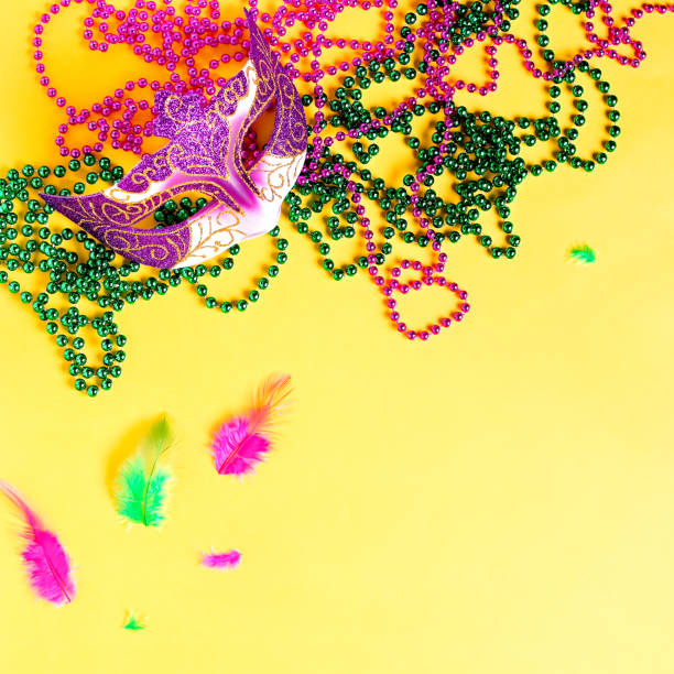 istock Mardi gras accessories flat lay on bright yellow background, top view, copy space. Frame with traditional Mardi gras beads, masks, feathers flat. Carnival holiday concept overhead 1206093990