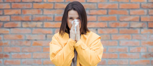 istock Sick young woman blowing her nose 1206097072