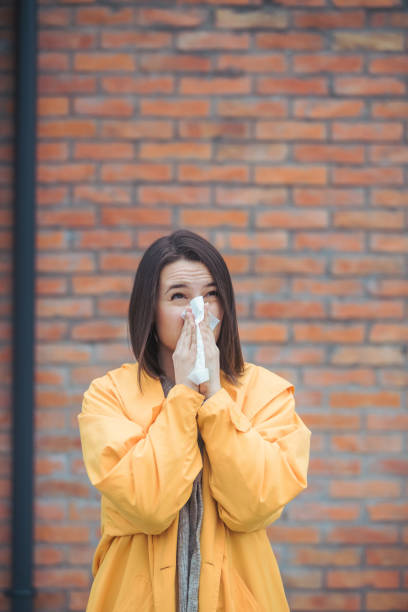 istock Sick young woman blowing her nose 1206097077