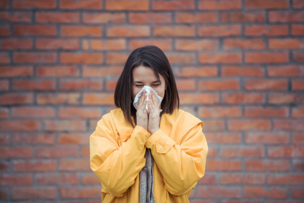 istock Sick young woman blowing her nose 1206097080