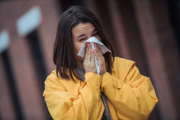 istock Sick young woman blowing her nose 1206097099