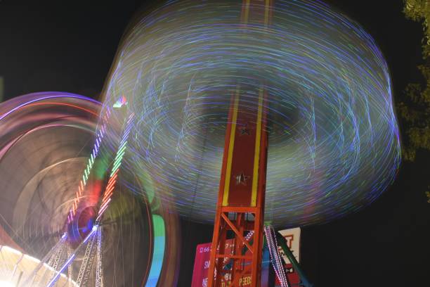 hyderabad numaish (exposição) - fotografia de longa exposição noturna, telangana, índia - ferris wheel wheel blurred motion amusement park - fotografias e filmes do acervo