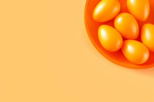 istock Close up of bright orange eggs on yellow background 1206104713