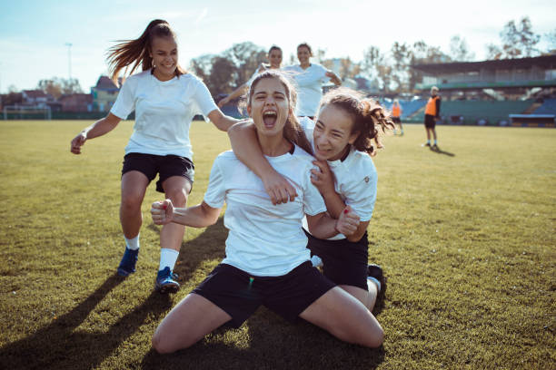 Goal Celebration Close up of a female soccer team celebrating a scored goal drill team stock pictures, royalty-free photos & images