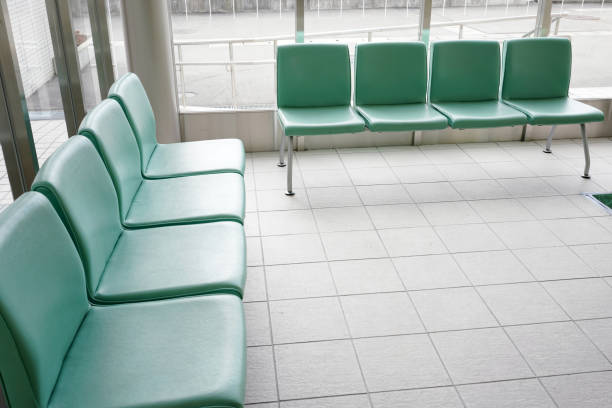 in a room there is a man sitting on a chair next to an ornamental plant, sitting alone waiting to be served