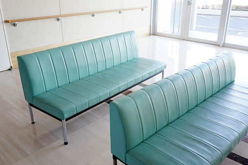 Hospital waiting room with empty green chairs