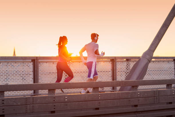 istock Young couple exercise on the bridge at sunset 1206140427