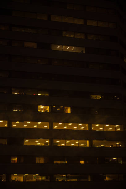 istock Night skyscraper close up, glowing window. Night work.Vertical shot. 1206140482