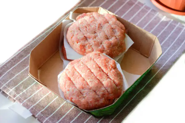 Photo of Plant based meat concept. Vegetable burger patties in carton tray. First non-soy plant meat