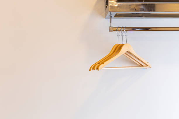 Wooden Three luxury coat hanger on brick wall inside the hotel bedroom interior.