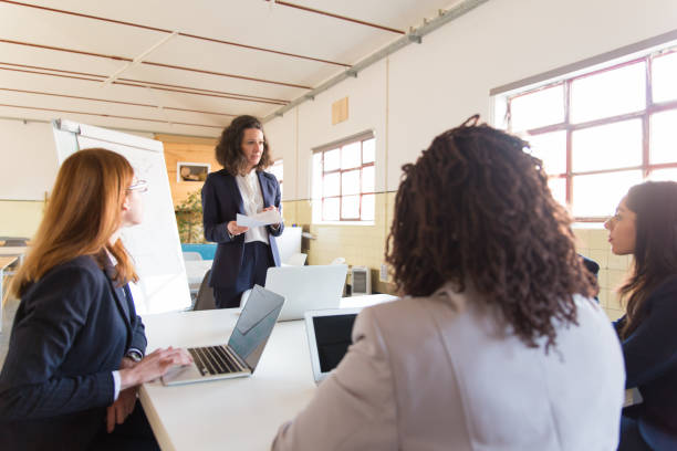 istock Business coach standing near whiteboard and holding documents 1206145472