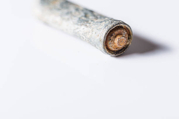 istock Damaged and old rusty battery close up still on a white background 1206146313