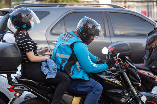 Manila, Philippines - February, 3, 2020: Motorcyclist commute in traffic on the roads of Makati