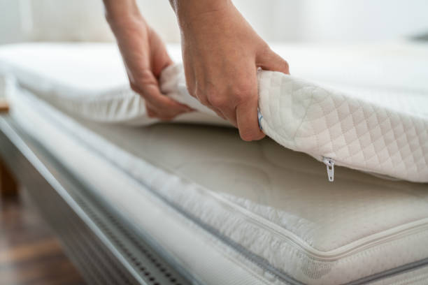 Mattress Topper Mattress Topper Being Laid On Top Of The Bed mattress stock pictures, royalty-free photos & images