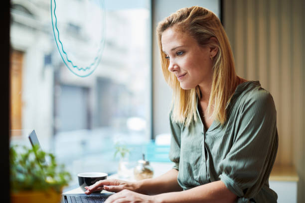 Free Stock Photo of A young blonde woman working on her laptop ...