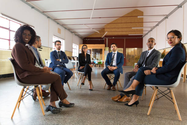 istock Business people sitting in chairs in circle 1206152641