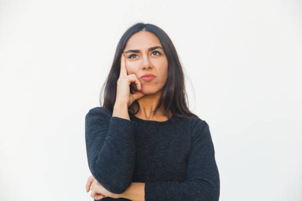 istock Thoughtful young woman holding hand on cheek 1206153687