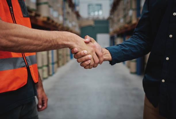 istock Close-up of two men handshake while concluding agreement about container rent and shaking hands 1206156615
