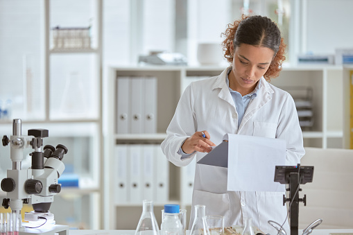 Shot of a young scientist going through paperwork in a lab