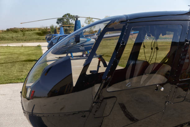 Cockpit of a grounded black helicopter on helipad Helicopter cockpit with seats in the cabin and closed door helicopter seat stock pictures, royalty-free photos & images