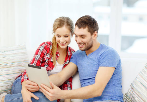 istock smiling couple with tablet pc computer at home 1206159686