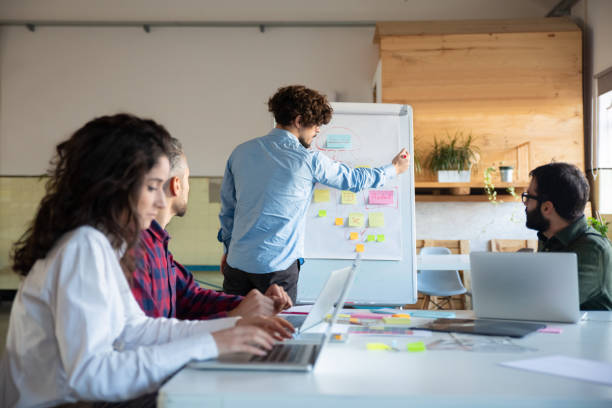 istock Concentrated young man explaining strategy to coworkers 1206159714