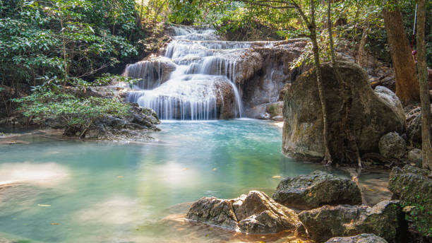 un petit étang près d’une chute d’eau de montagne - waterfall tropical rainforest erawan thailand photos et images de collection