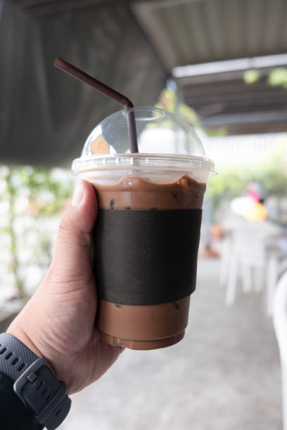 istock Iced mocha coffee in hand. Close up 1206164234