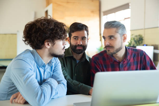 istock Smiling young colleagues working with laptop 1206165593