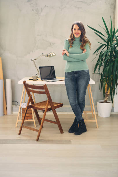istock Young attractive female standing in modern office and looking at camera. 1206166332