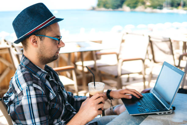 istock Surfing the net and drinking ice coffee at seaside 1206166448
