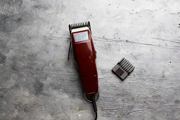 machine for a hairstyle. Barbershop. Hair clippers isolated on blue background. The machine for a hairstyle. Hair clippers isolated on gray wood background