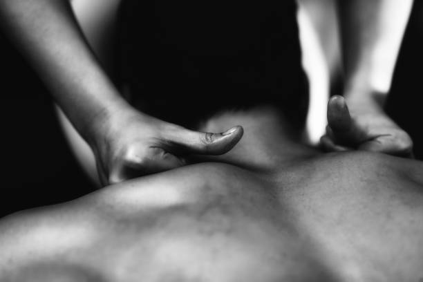 Physiotherapist massaging male patient with injured neck muscle. Sports injury treatment