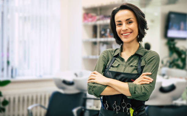 Smile of the professional. Portrait of a gorgeous young hairstylist standing with folded arms near her workplace in the salon. salons and hairdressers stock pictures, royalty-free photos & images