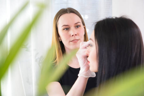 istock Professional eyebrow correction. Woman having professional eyebrows correction in studio. 1206177577