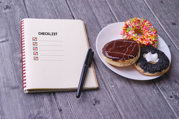 istock Checklist concept - checklist box with red checkmark, paper, doughtnut and a pen with checklist word on wooden table 1206178444