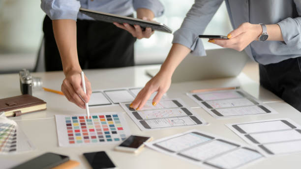 istock Close up view of UI developer team brainstorming on their project with smartphone and digital tablet 1206178527