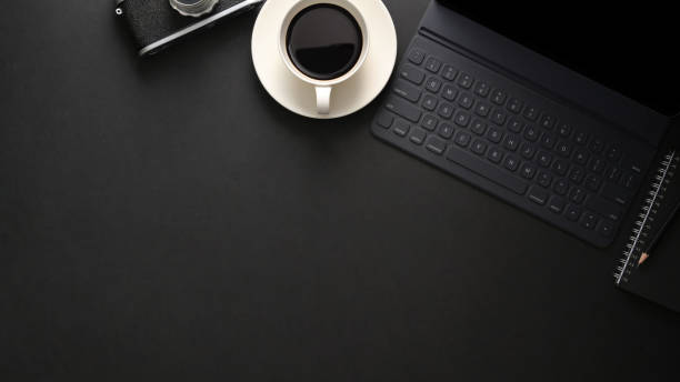 istock Top view of workplace with wireless keyboard, copy space, camera and coffee cup on black table 1206178761