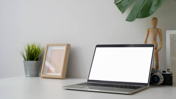 istock Cropped shot of workplace with blank screen laptop, camera  and decorations 1206178768