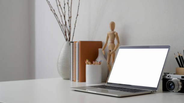 istock Cropped shot of workplace with blank screen laptop, camera  and decorations 1206178785