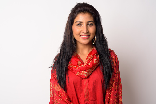 Studio shot of young beautiful Persian woman wearing traditional clothing against white background