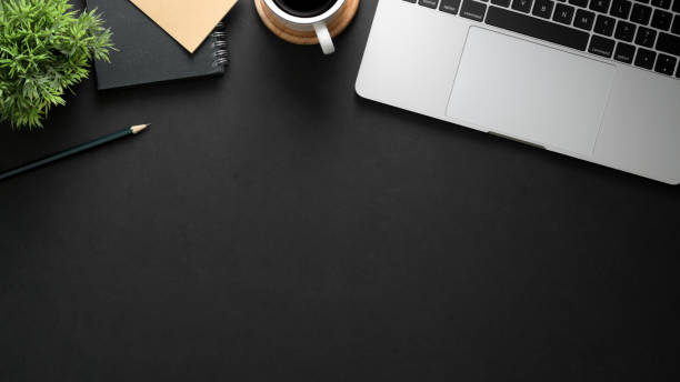 istock Top view of workplace with laptop, copy space, stationery and coffee cup on black table 1206182215