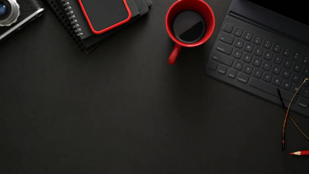 istock Stylish workplace with wireless keyboard, smartphone, copy space and coffee cup on black table 1206182753
