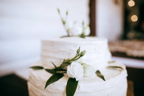 istock White wedding cake decorated with white roses and green branches with leaves 1206183600