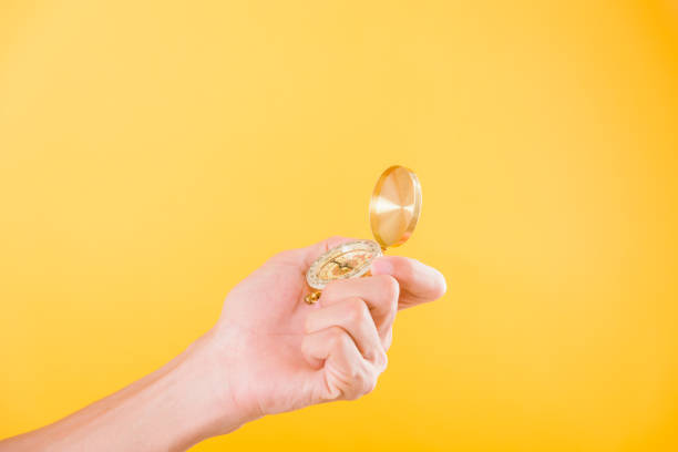 istock Hand holding antique brass compass isolated 1206187646
