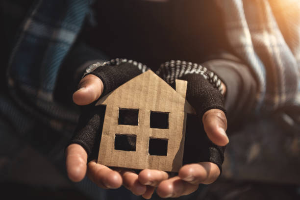 Hands of Homelessness Poor man holding the paper house hope to have family home and warm home Hands of Homelessness Poor man holding the paper house hope to have family home and warm home homelessness stock pictures, royalty-free photos & images